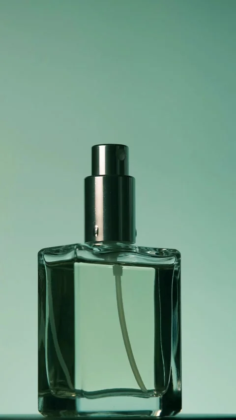 Vertical video of a rotating perfume bottle that stops facing front. Vidéo 327371857