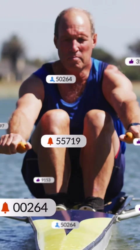 Vertical video: Rower starting stroke for fitness while social media pings Stock Footage 332734524