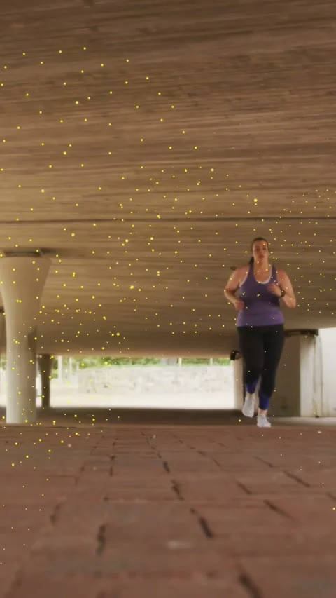 Vertical video: Runner starting far, approaching camera underpass, golden sparks Stock Footage 335513370