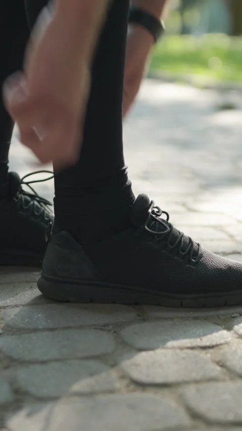 Vertical Video of Runner Tying Shoelaces Before Jogging Workout. Triathlon Stock Footage 302265420