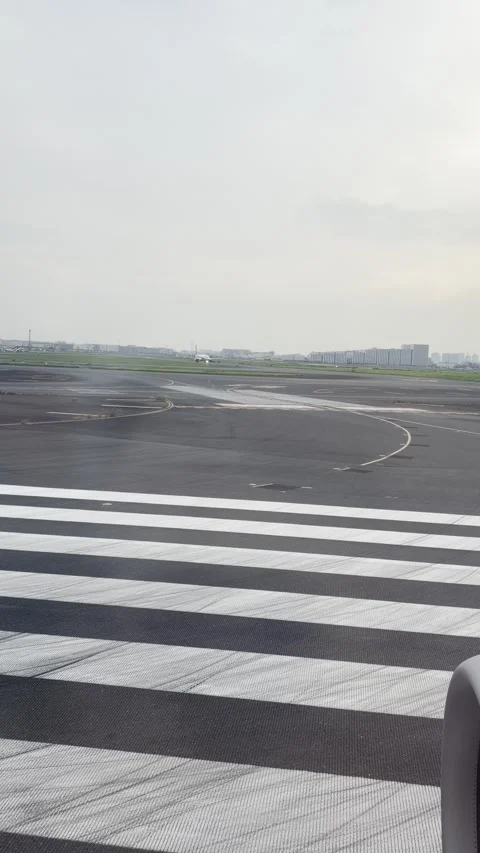 Vertical video of runway and scenery from airplane passenger window Stock Footage 346703524