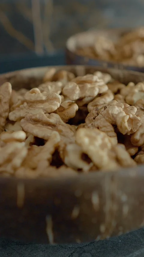 Vertical video Rustic bowls filled with fresh walnut kernels for a natural feel Stock Footage 329617499