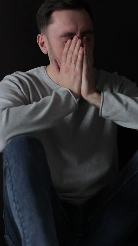 Vertical video Sad man sitting in the dark leaning against the wall in home. Stock Footage 337649806