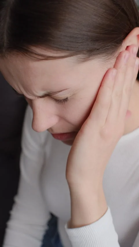 Vertical video of sad young brunette female holding painful ear, strong ache Stock-Footage 295925659