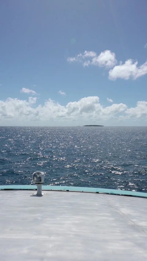 Vertical video of Sailing on the ocean from the bow of a boat on a sunny day in Vidéo 330879111