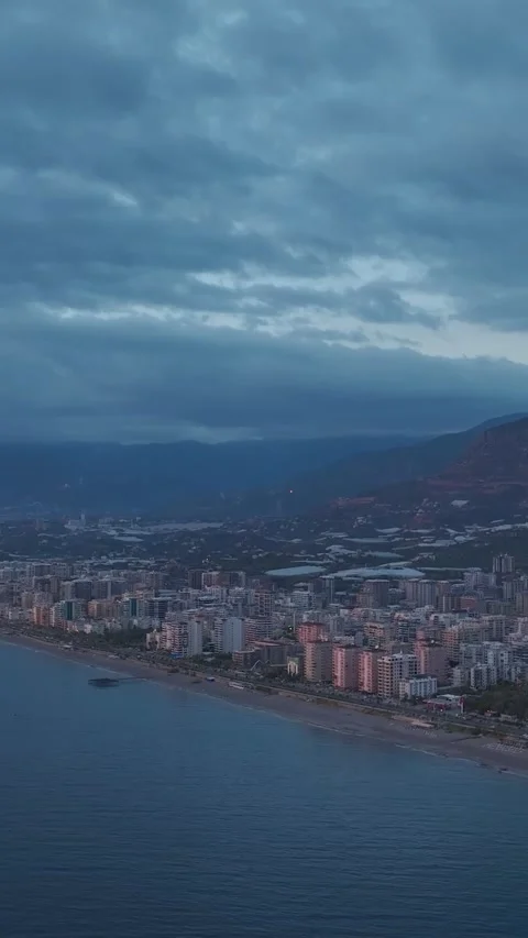 Vertical Video: Scenic sunset view of the city from the sea with glowing Stock Footage 297656616