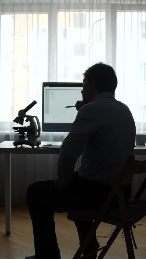 Vertical video scientist in modern lab studies data on a computer while Stock Footage 345530381
