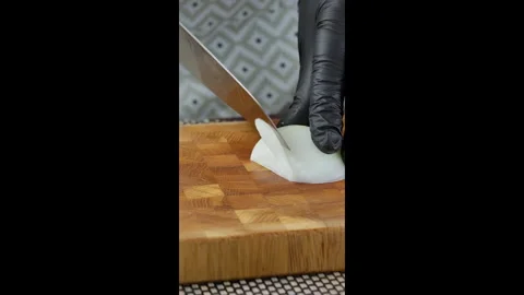 Vertical video screen. Cook with a chef's knife slices onion on a wooden board. Stock Footage 302638577