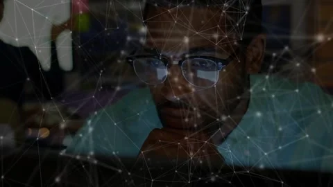 Vertical video: Screen glow causing man in specs leaning, studying at dim office Stock Footage 334182970