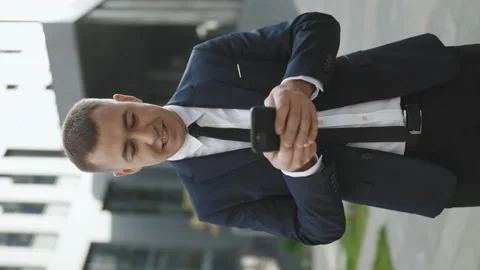 Vertical Video Screen of Man smiling and using mobile phone over office building Stock Footage 194520936