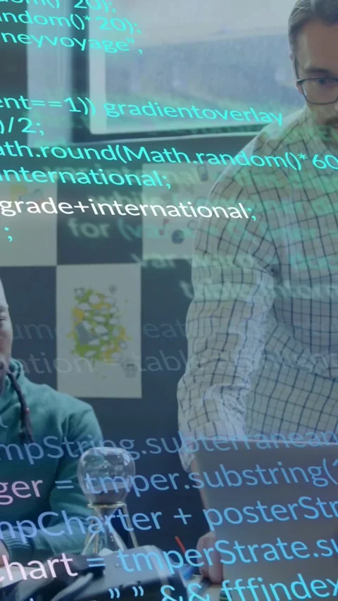 Vertical video: Seated dev typing starting tech code overlay while lead using Stock Footage 330509559