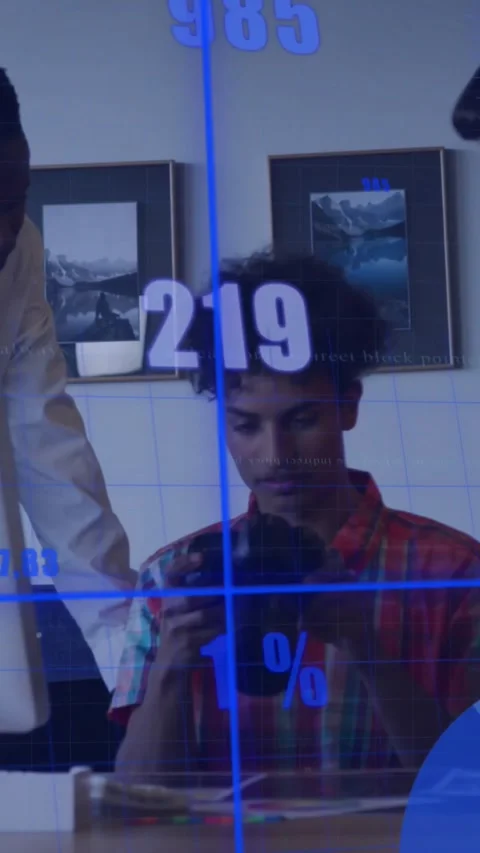 Vertical video: Seated man checking DSLR, team pointing, blue data morphing into Stock Footage 332278418