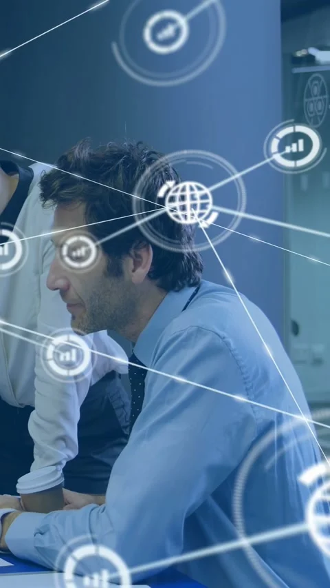 Vertical video: Seated man reading chart, peer leaning, sparking AR web mapping Stock Footage 332806833