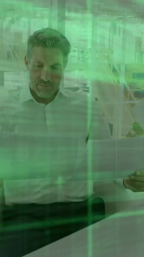 Vertical video: Seated man tapping tablet and reviewing code, causing green code Stock Footage 334546950