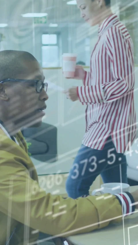 Vertical video: Seated man working tech overlays moving over keys as worker Stock Footage 334547502