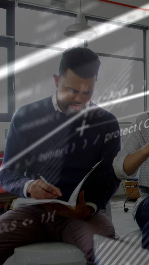 Vertical video: Seated man writing notebook notes during tech review, code Stock Footage 333721096
