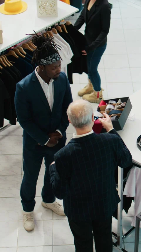 Vertical Video Senior designer teaching his apprentice to match ties on elegant Video stock 264087280