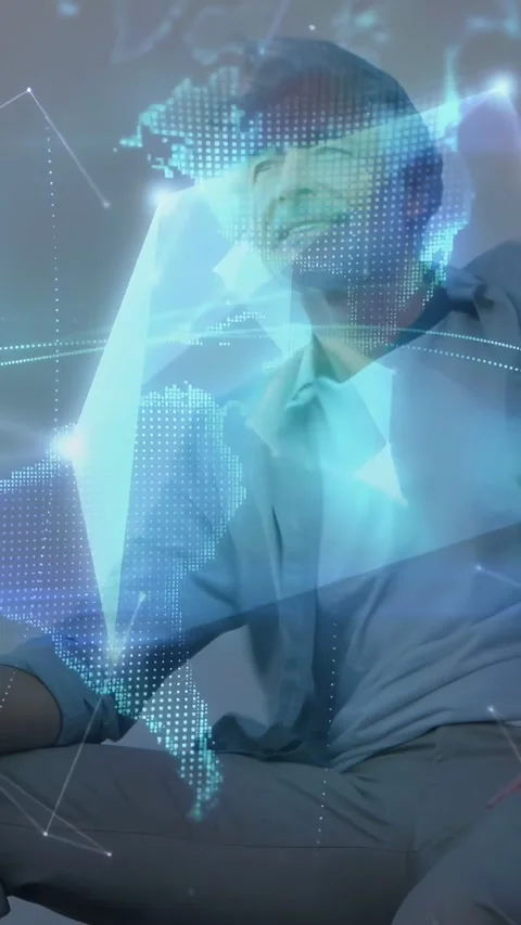 Vertical video: Senior man seated watching nodes drifting as holo globe wrapping Stock Footage 334387174