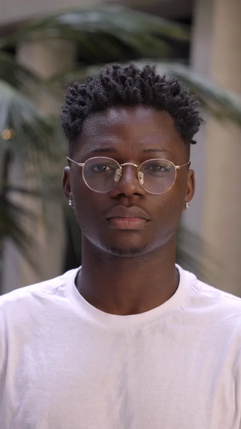 Vertical video of serious black man, concentrating and looking at camera Stock Footage 236574507