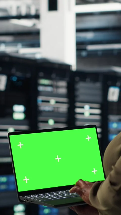 Vertical video Server room admin uses green screen laptop to upgrade mainframes Stock Footage 316860304