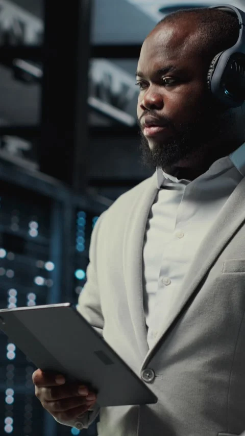 Vertical video Server room programmer wearing headphones troubleshooting errors Stock Footage 311489866