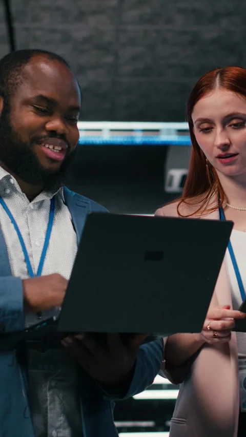 Vertical video Server room teamworking colleagues using tablet and laptop Stock Footage 330204171