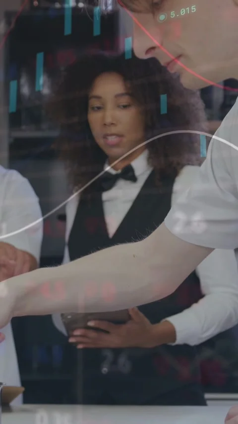 Vertical video: Server tapping tablet in kitchen, guiding chefs plating as data Stock Footage 340133446
