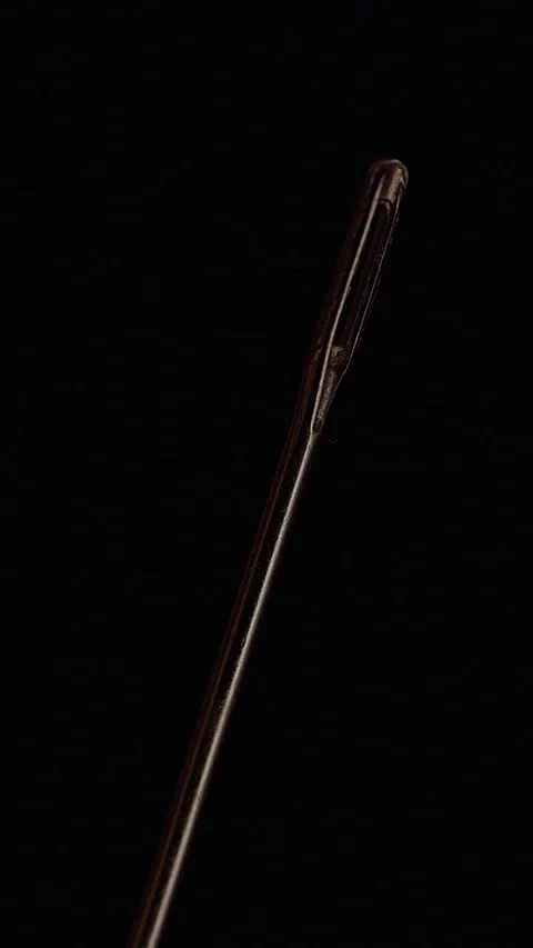 Vertical video. Sewing Needle Eye Shown in Extreme Macro Against a Black Backgro Stock Footage 341415892