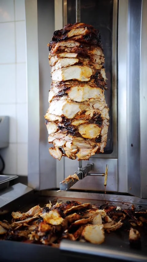 Vertical video of shawarma chicken meat being cut before making traditional Stock Footage 280386523