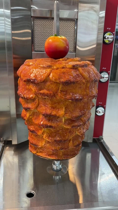 Vertical video of shawarma meat rotating on a vertical spit. Stockbeeldmateriaal 323778428