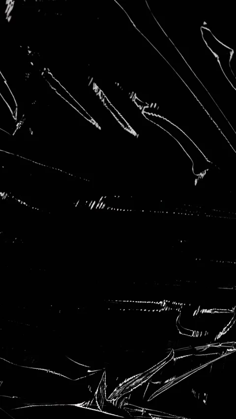Vertical video: Shifting light driving crumpled foil showing rotating folds for Stock Footage 348492173