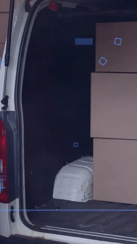 Vertical video: Shifting into van, delivery worker lifting box to load for Stock Footage 334598612