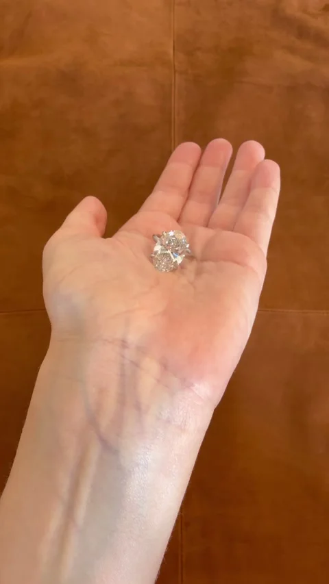 Vertical video showcasing elegant oval diamond ring as hand opens 스톡 동영상 314786715