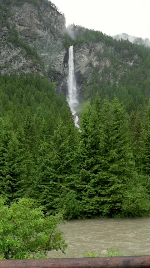A vertical video showcasing a tall waterfall cascading down a rugged mountain Stockbeeldmateriaal 282149586