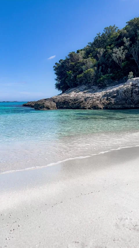 A vertical video showing a sandy beach with crystal-clear water in slow mot.. Stock Footage 286231458