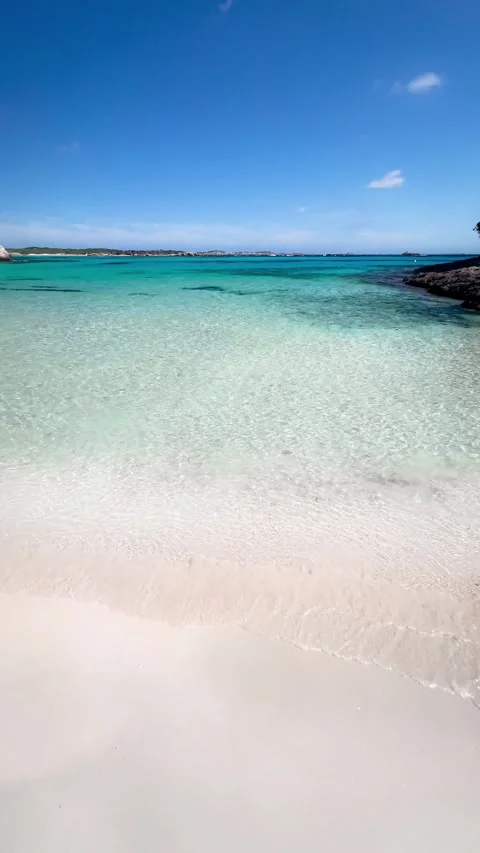 A vertical video showing a sandy beach with crystal-clear water in slow mot.. Stock Footage 286231494