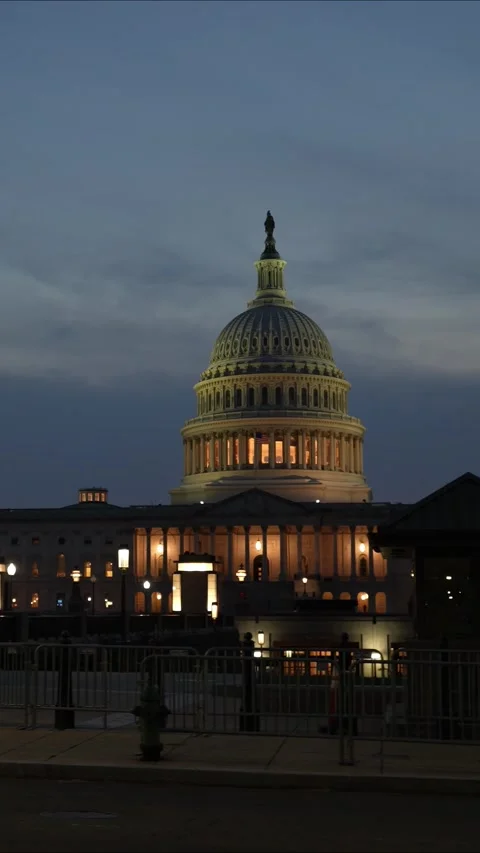 Vertical video showing the US Capitol with lights and flags waving in Washington Stock Footage 314658078