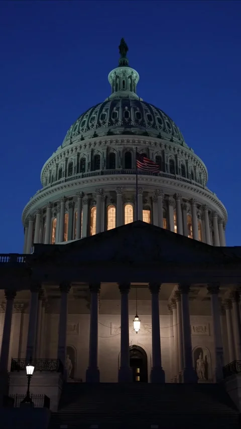 Vertical video showing the US Capitol with lights and flags waving in Washington Stock Footage 314658409