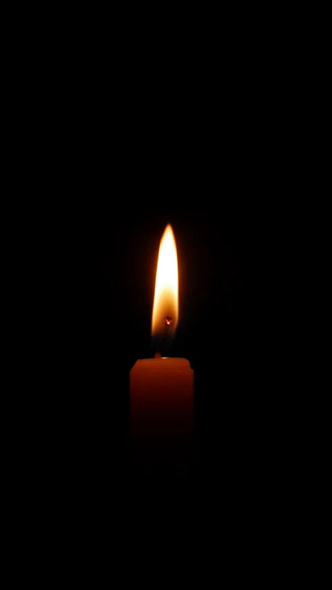 This vertical video shows a candle burning in empty darkness where the gentle Stock Footage 324889796