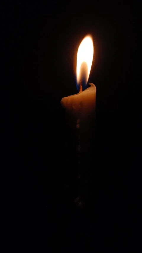 A vertical video shows a candle flame on a quiet night. Stock Footage 342947875