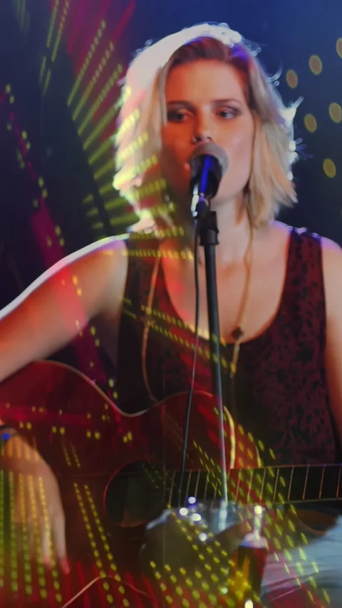 Vertical video: Singer after focus strumming while projections animating across Stock Footage 334397302