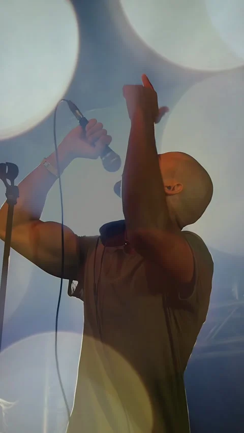 Vertical video: Singer holding mic, singing and causing bokeh to hide then Stock Footage 333487195