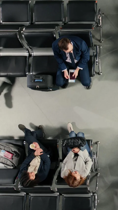 Vertical video Sitting on empty seats, airport and travelers in terminal Stock Footage 334852839