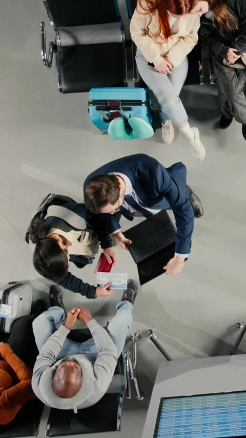Vertical video Sleeping, flight schedule screen and sisters in airport lounge Video stock 334850919