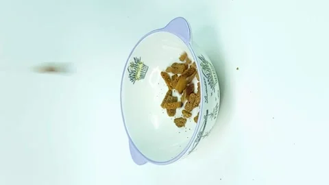 Vertical video slices of bread or crakers are poured into a glass plate isolated Stockbeeldmateriaal 142270245