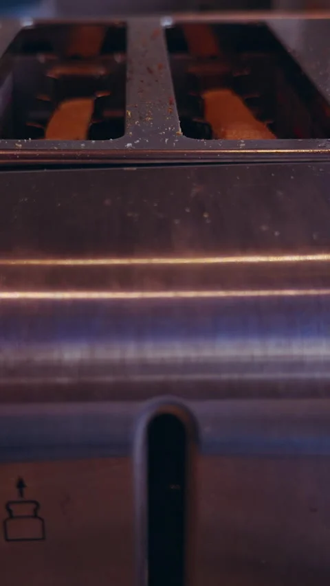 Vertical video. Slices Of Bread Rising From Stainless Steel Toaster During Break Stock Footage 337058383
