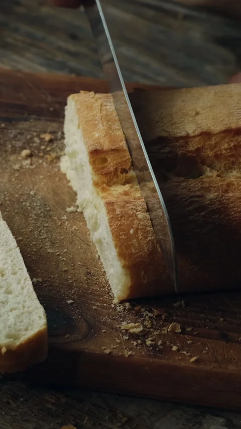 Vertical video. Slicing freshly baked loaf of ciabatta bread Stock Footage 340333671
