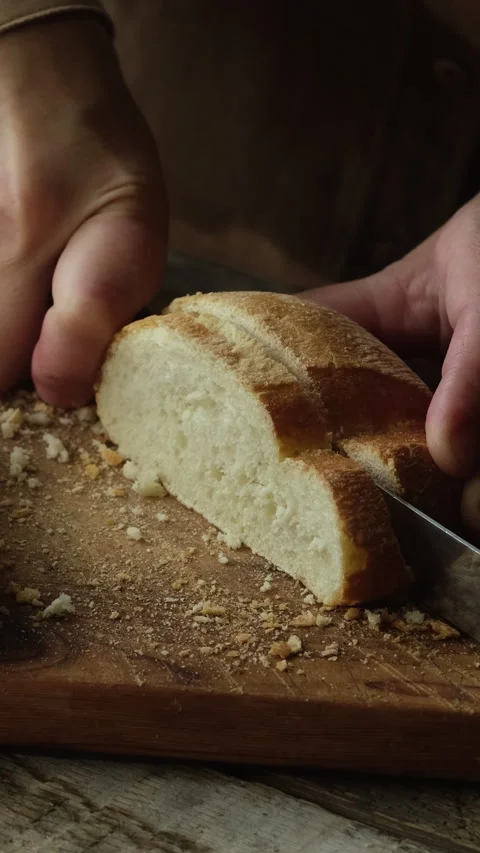 Vertical video. Slicing loaf of ciabatta bread on wooden cutting board. Stock Footage 340333682