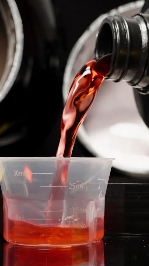 Vertical video. Slider Shot Across a Black Table as Red Sports Supplement Is Stock Footage 277471733