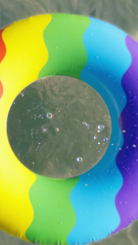 Vertical video. Slow Motion Camera Rising From Underwater Through a Colorful Inf Stock Footage 339192225